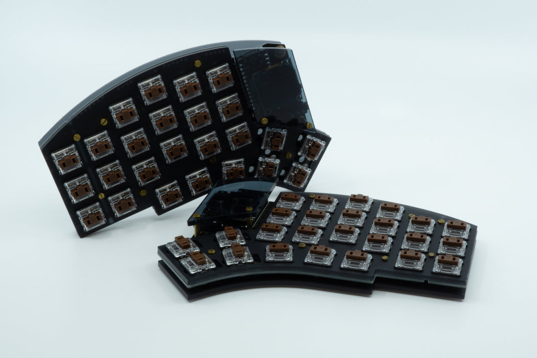 A front photo of a Kyria in a midnight plate case with one half on its side, showing dark tinted OLED windows.