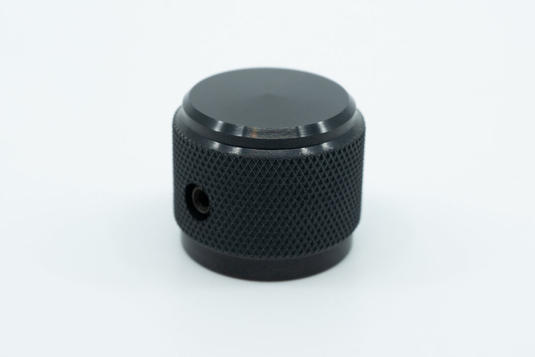 A macro photo of a black knurled aluminium encoder knob.