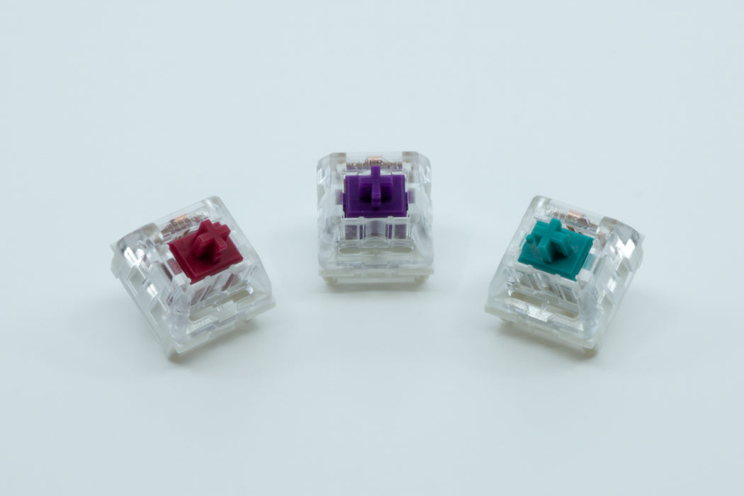 A front view of three Kailh Pro switches next to each other: Kailh Pro Burgundy, Purple and Light Green.