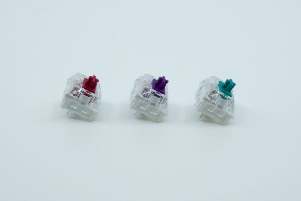 A side view of three Kailh Pro switches next to each other: Kailh Pro Burgundy, Purple and Light Green.