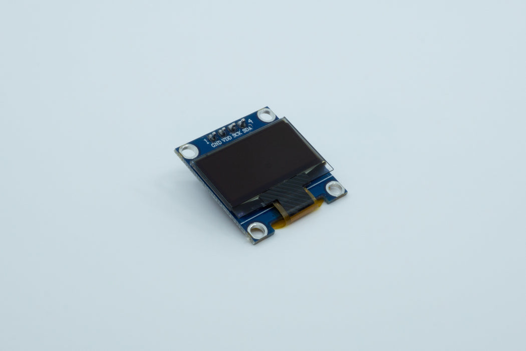 An angled top view of a blue 128 by 64 pixel SSD1306 OLED display.
