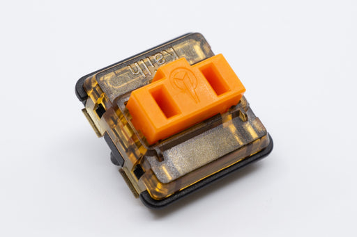 Top view of a single Kailh Choc Low Profile Sunset switch. It is orange, with an orange tinted translucent top and a black bottom housing.